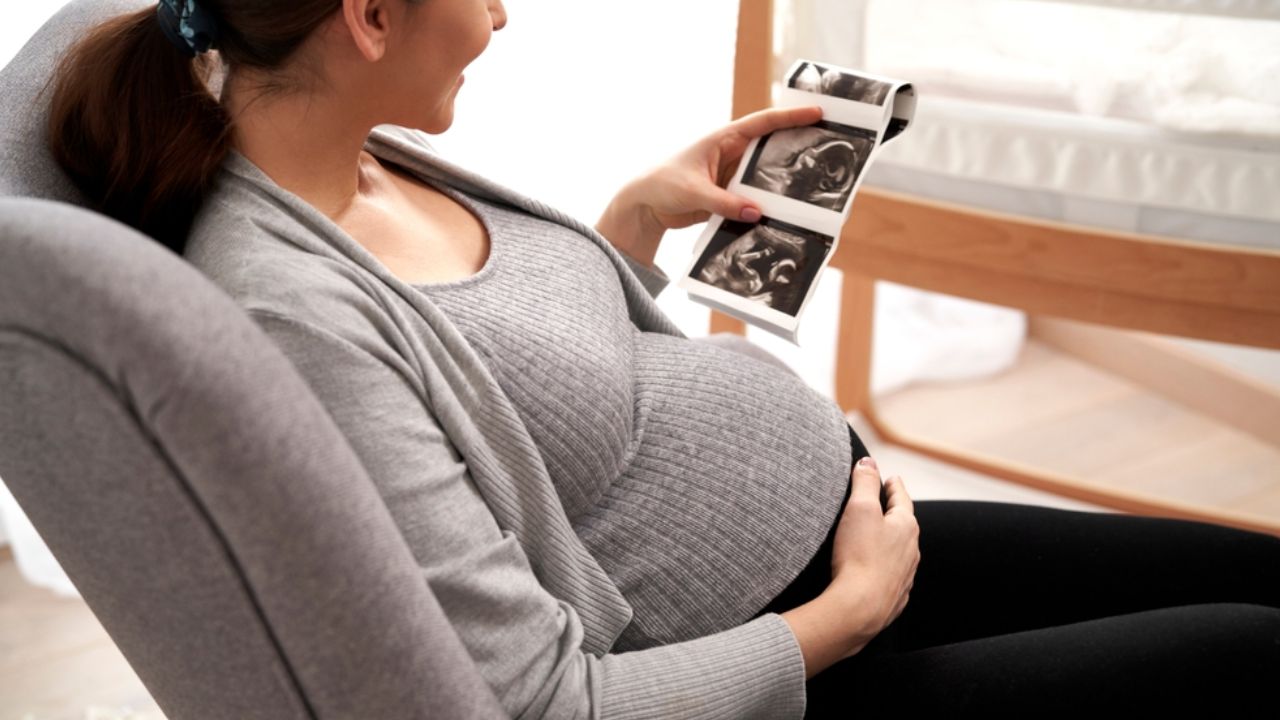 mulher grávida segurando um ultrassom obstétrico