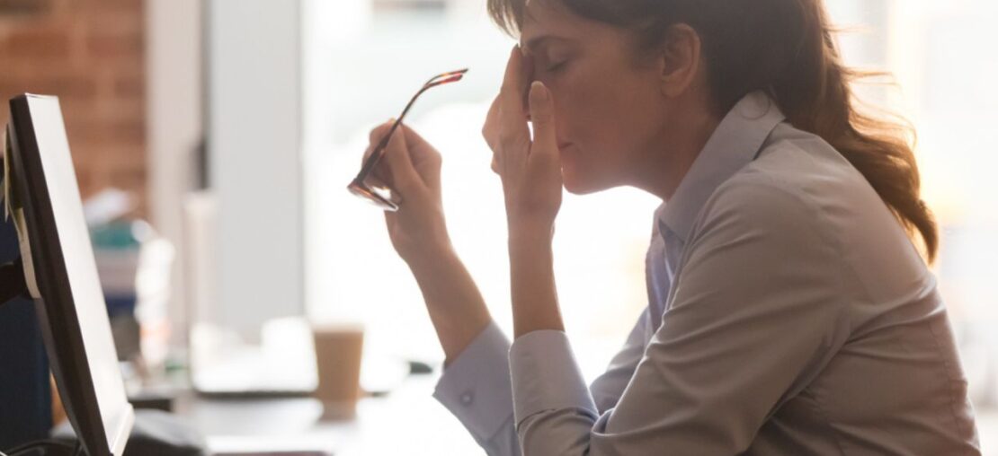 mulher no trabalho sentindo esgotamento físico e mental