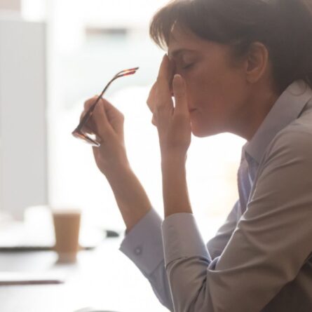 mulher no trabalho sentindo esgotamento físico e mental