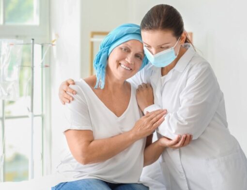 Uma médica e uma senhora portadora de câncer se abraçando.