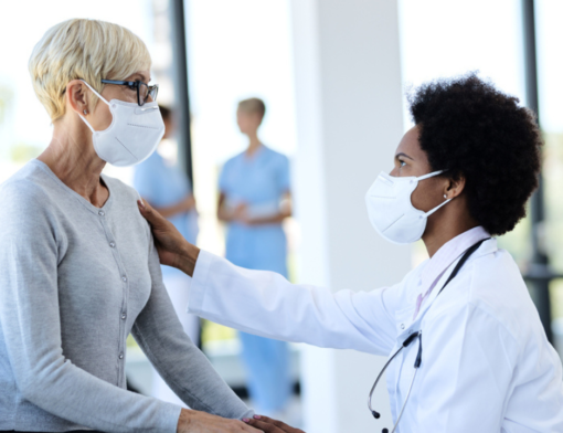 Uma médica infectologista atendendo paciente idosa com algum sinal de infecção.