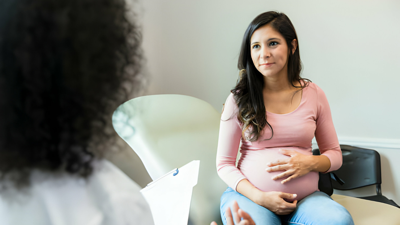 Uma ginecologista e obstetra orientando uma grávida sobre os cuidados durante esse período.