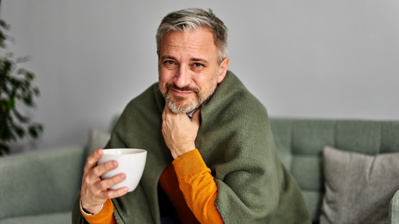 Um homem tomando remedio caseiro para dor de garganta.