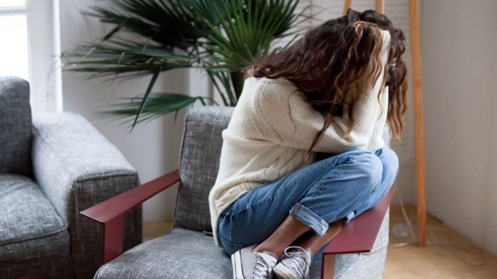 Uma jovem sofrendo por sintomas de trauma psicológico.