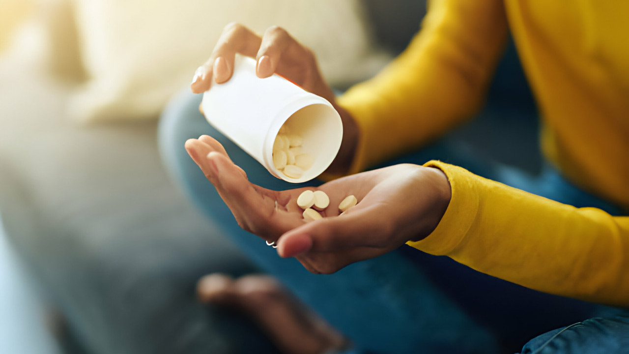 Uma mulher tomando medicação para tratar cólica e sangramento fora do período menstrual tomando anticoncepcional.