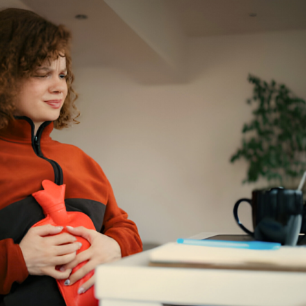 Uma mulher sentindo cólica fora do período menstrual.