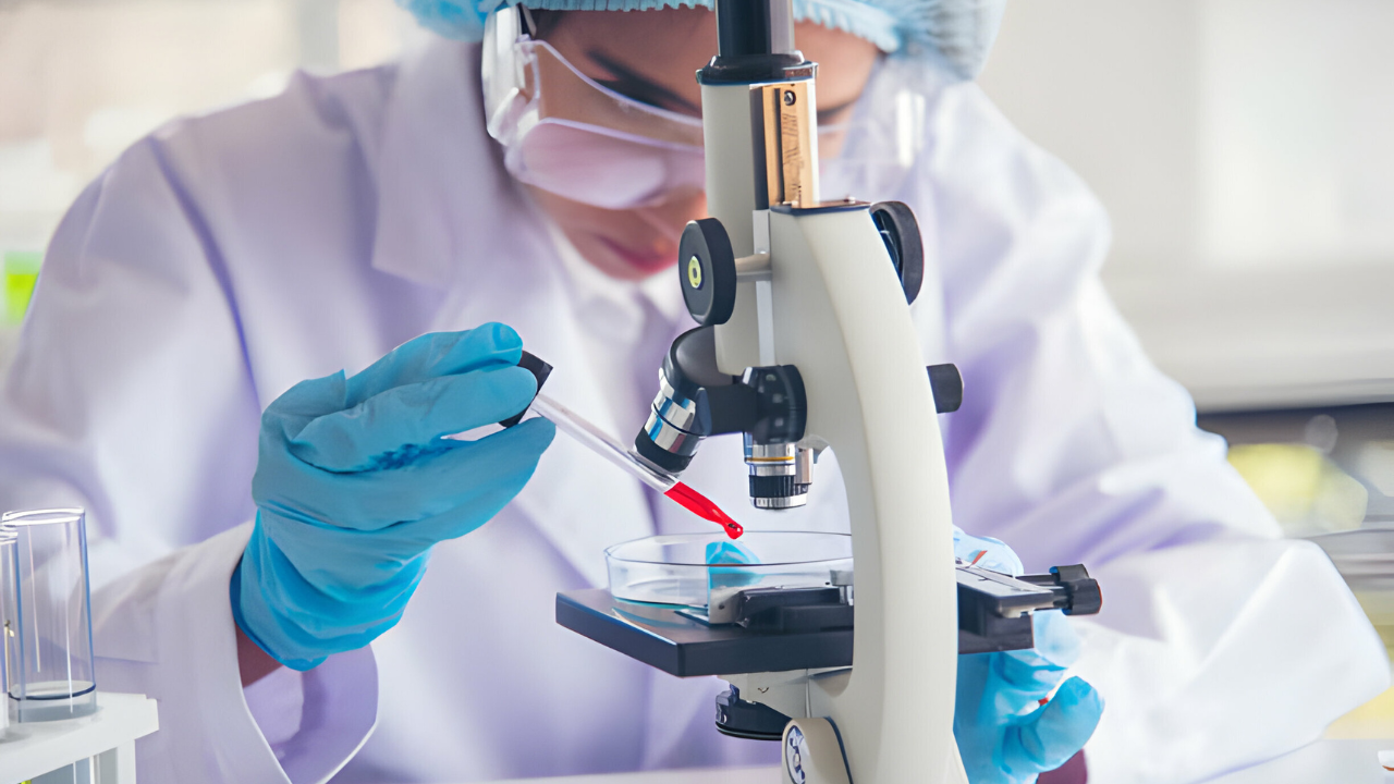 Profissional da infectologia realizando análise em laboratório.