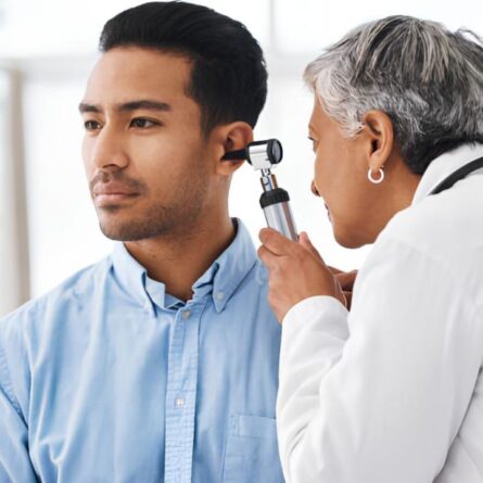 Médico otorrinolaringologista avaliando ouvido de paciente