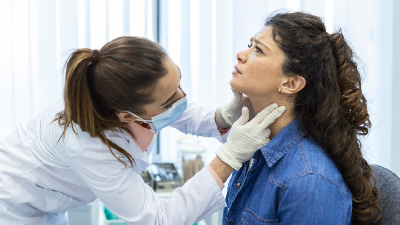 Médica analisando pescoço de paciente com sintoma de câncer de tireoide