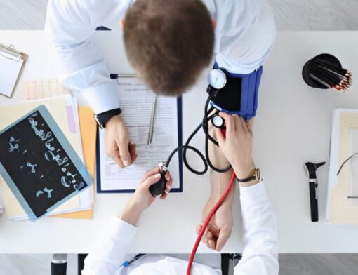 Visão panorâmica de médico fazendo a medição da pressão arterial de paciente em consultório