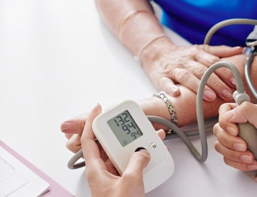 Zoom nas mãos de médico realizando a medição de pressão em paciente