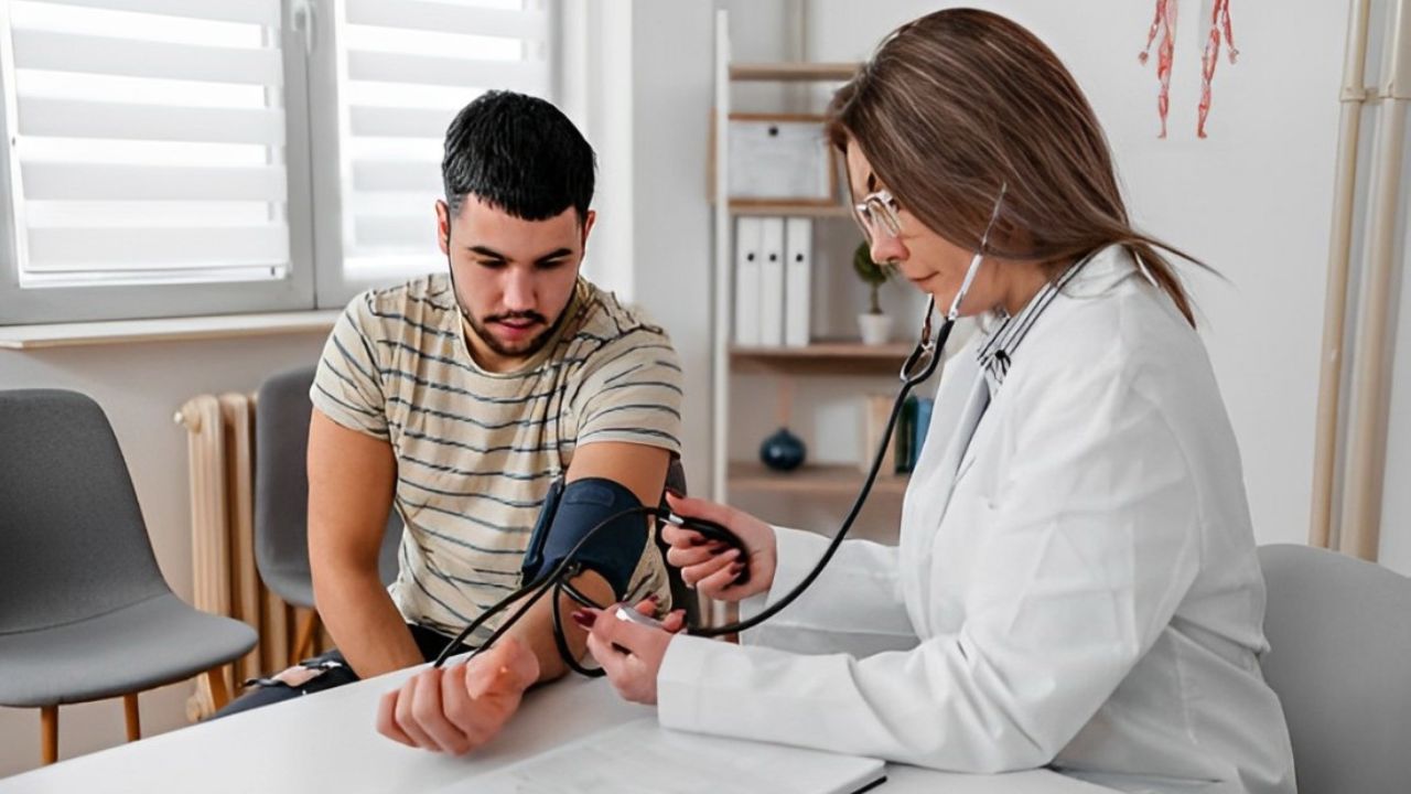 Médica medindo pressão de paciente em consultório 