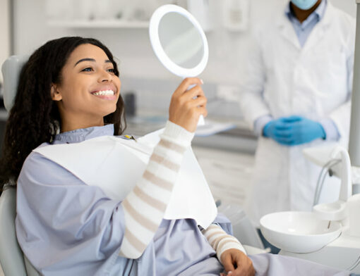 Mulher observando seu sorriso após fazer clareamento dental valor