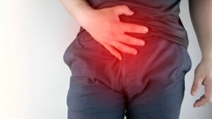 Zoom em pessoa segurando região intestinal por conta de desconforto