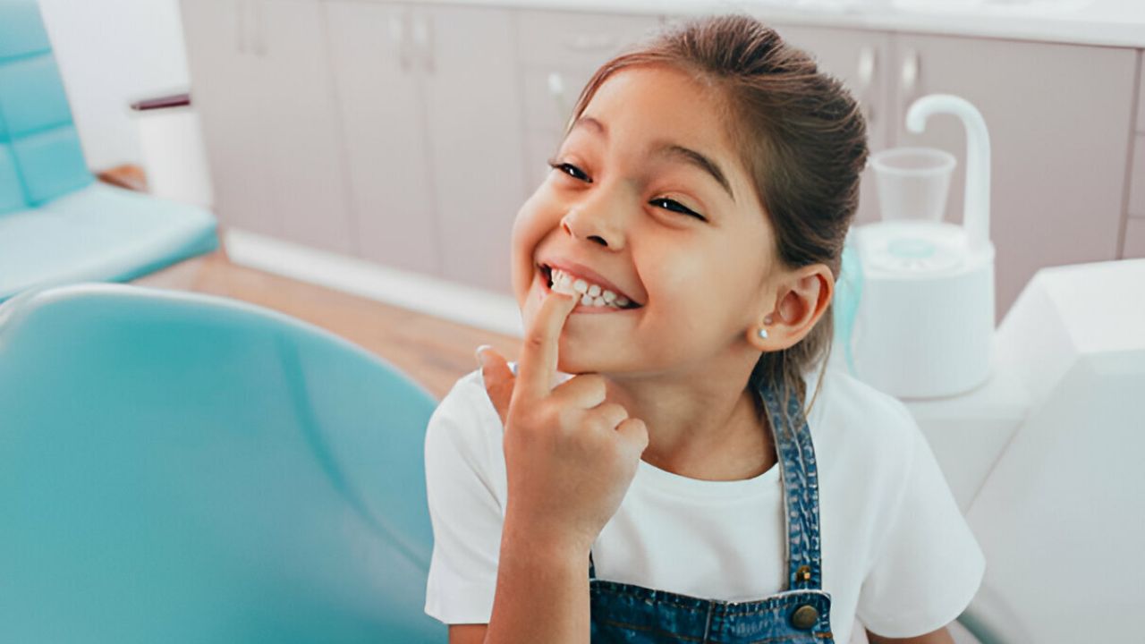 menina sorrindo mostrando seus dentes de leite 