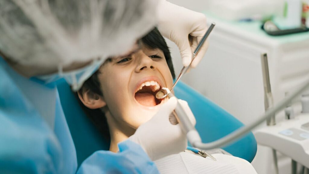 Zoom em menino recebendo atendimento de odontopediatra