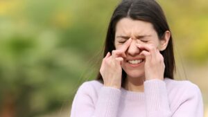 Mulher com mãos sobre olhos por conta de ardência