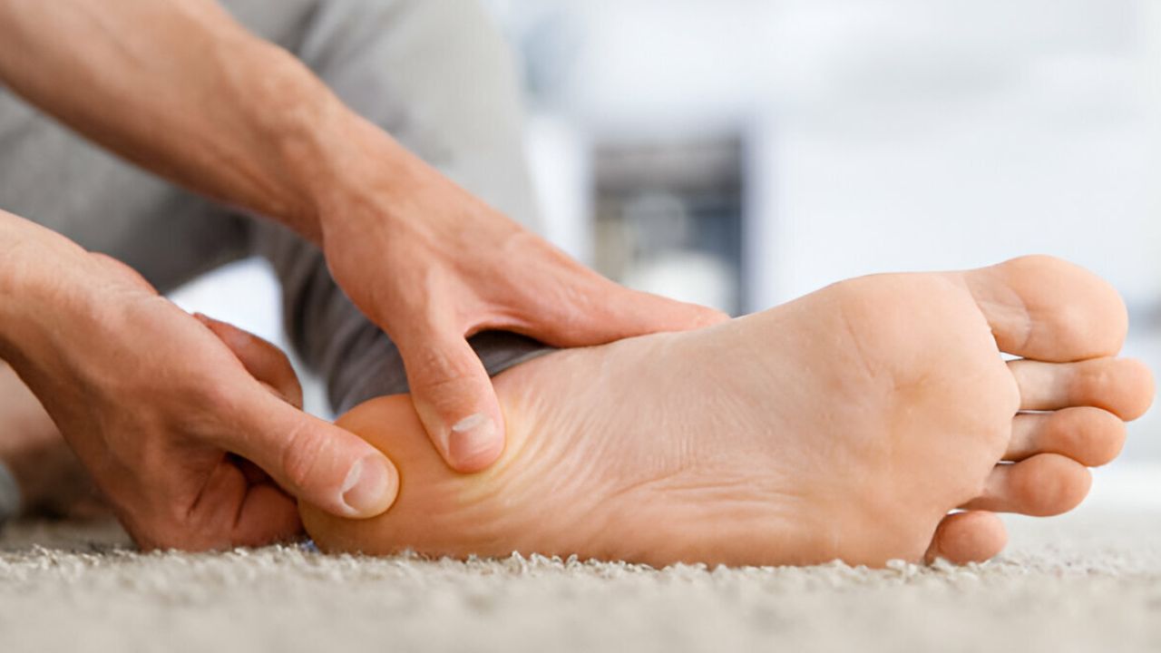 Zoom em pé sendo agarrando por conta de pé formigando