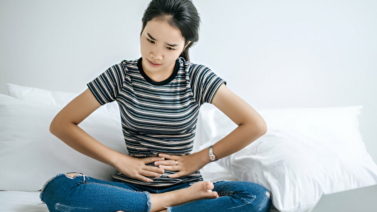 Mulher apertando região do intestino por conta de hérnia inguinal