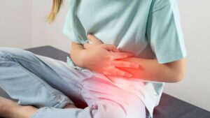 Mulher apertando a barriga por conta de desconforto causado por hérnia umbilical