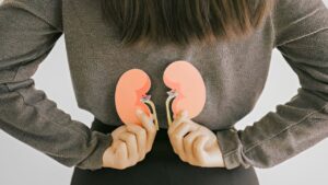 Mulher segurando desenhos de rins sobre suas costas