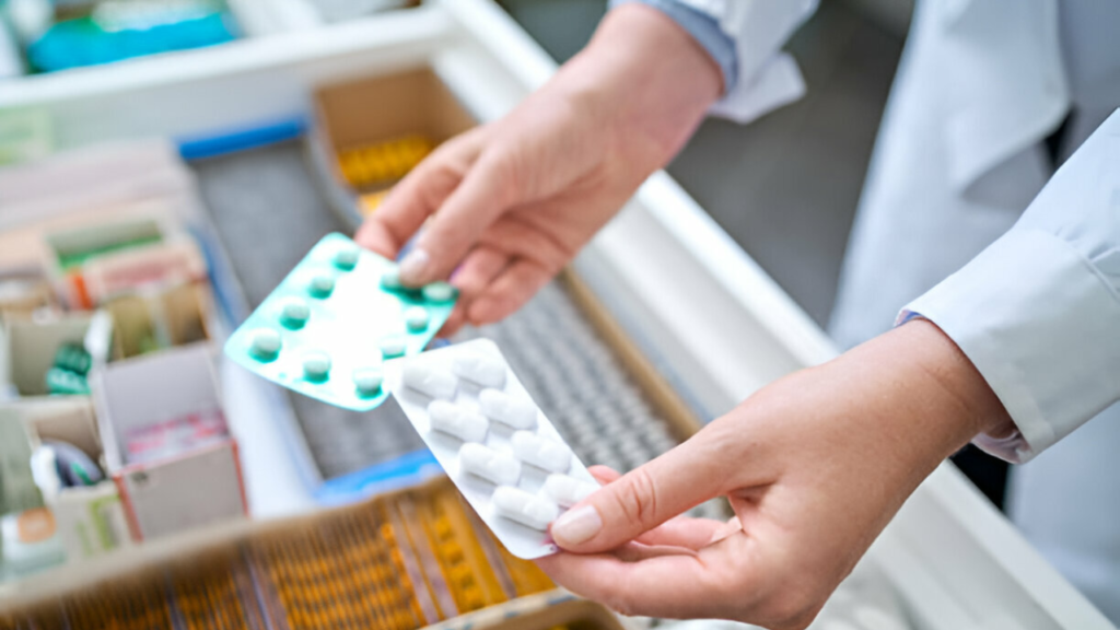Mãos pegando remédios de vermes em farmácia